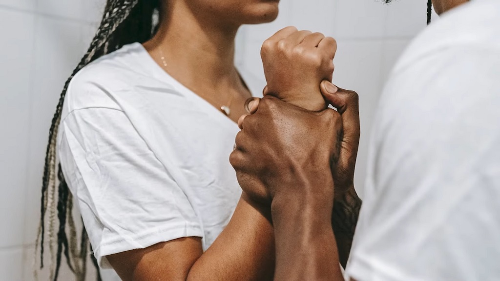 A close-up of a person grabbing another's wrist tightly