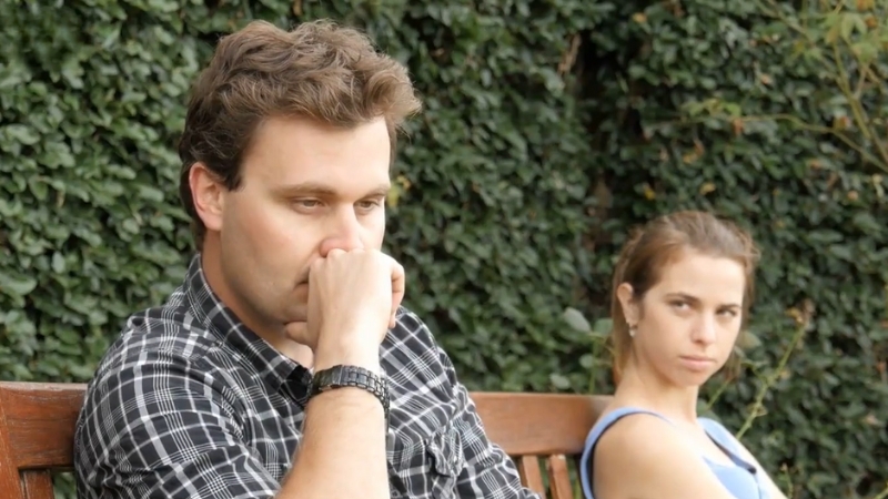 A Couple Sits Apart, with One Partner Looking Away, Showing Signs of Tension or Disagreement