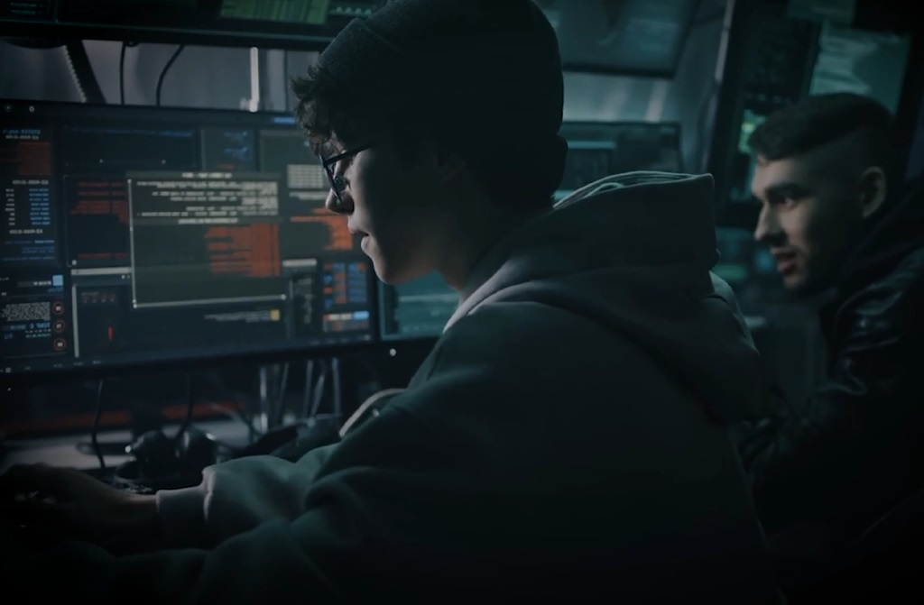 A young guy is hacking a computer