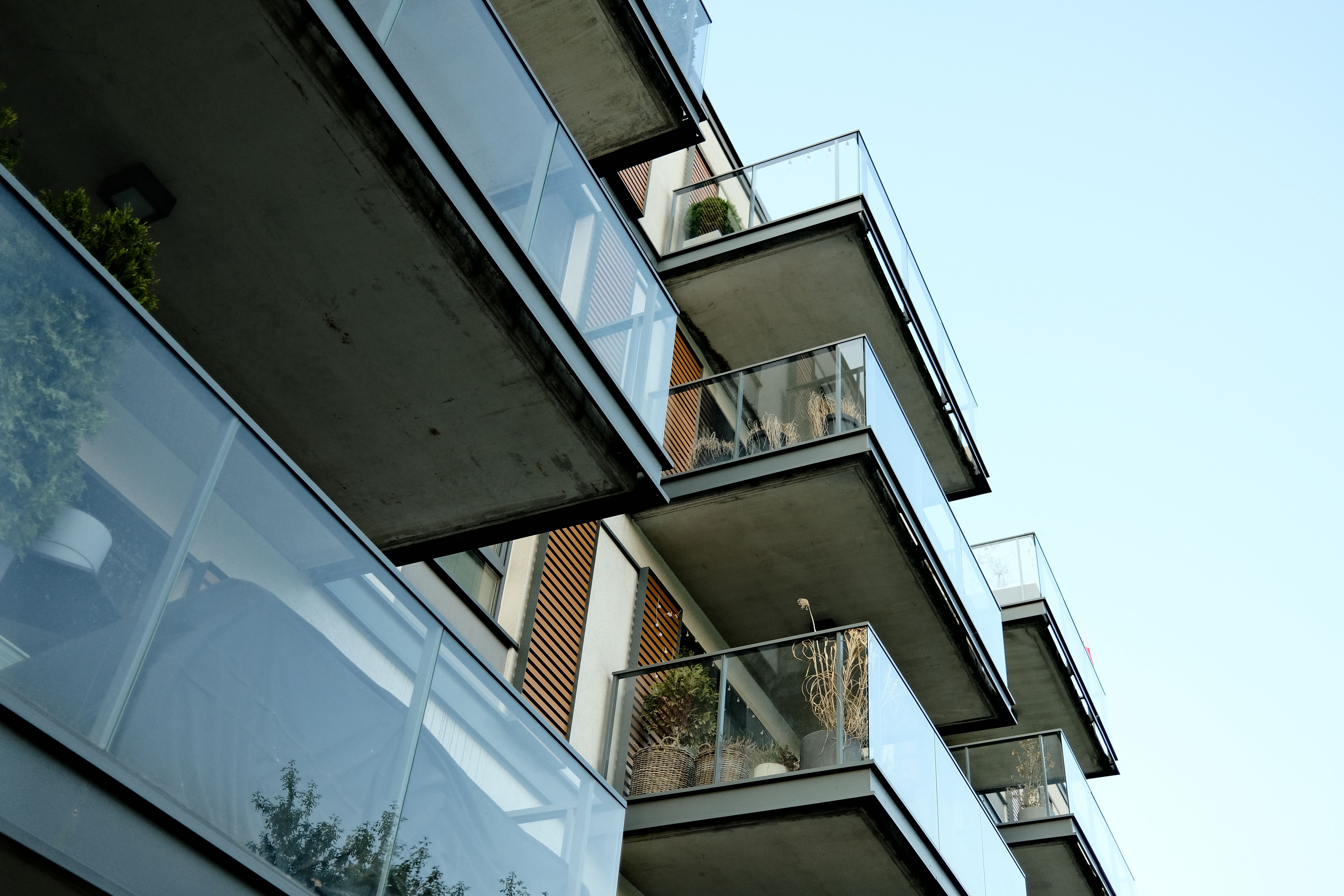 Modern residential building with glass balconies under a clear sky