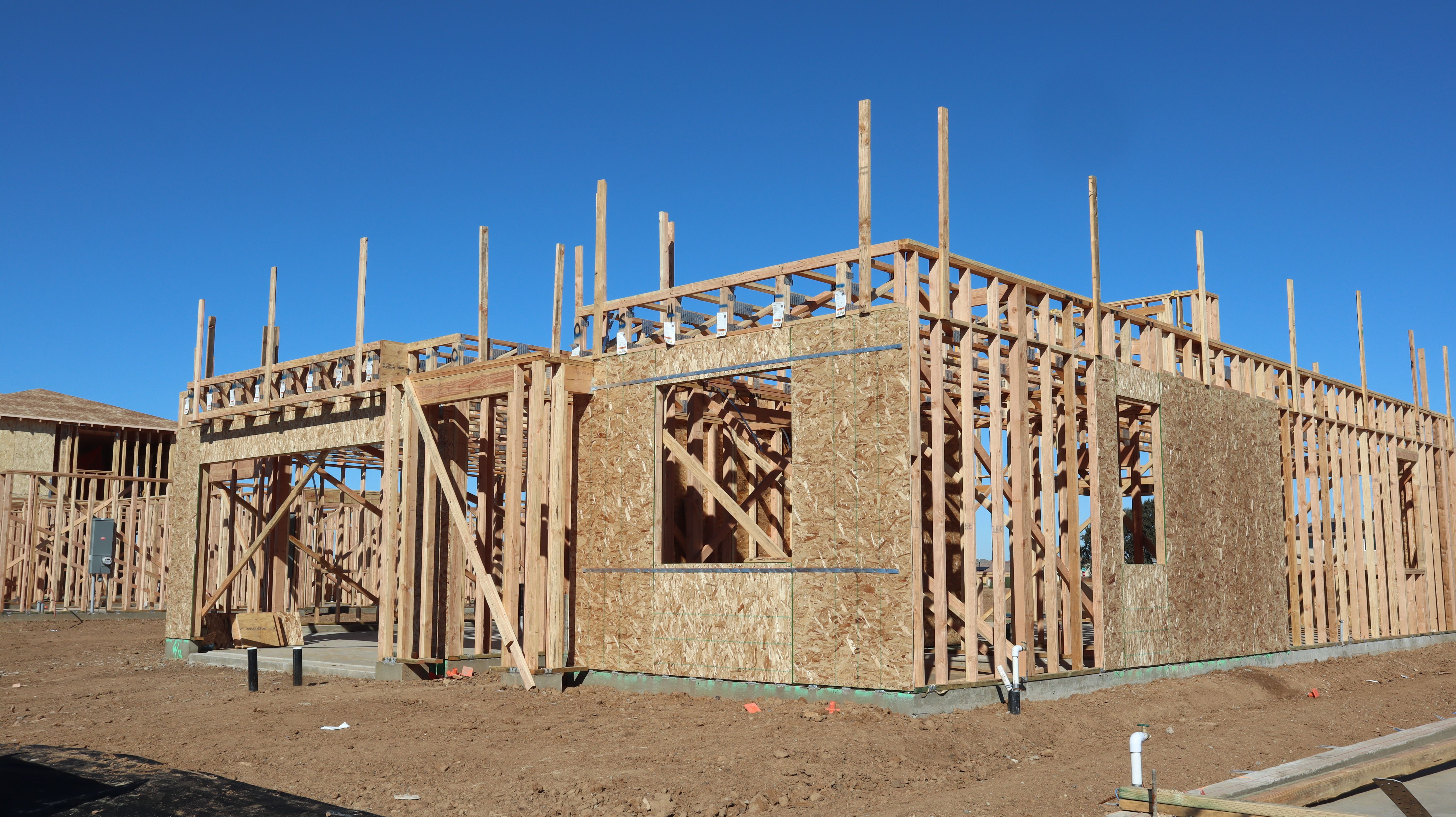 Wooden frame house under construction on a sunny day